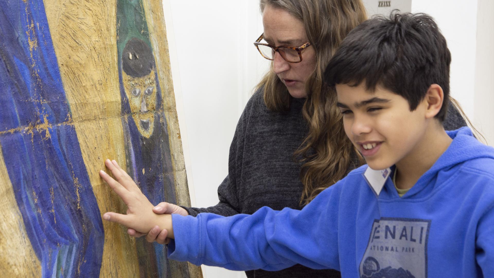 Carolina Ossa invitó a un niño no vidente a tocar la pintura Justice du Monde para que tuviera su experiencia perceptiva. (Archivo CNCR, Pérez, T., 2019)