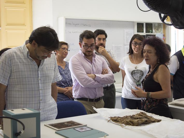 La visita sigue en el Laboratorio de Arqueología observando restos de textiles.