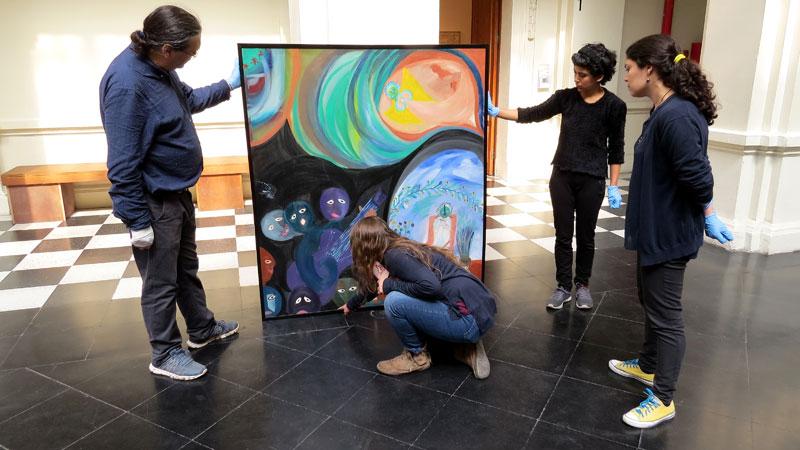 Durante la evaluación de la obra "La muerte del angelito"( ca.1964), Carolina Ossa, jefa del Laboratorio de Pintura del CNCR , junto al equipo del MAC ( Archivo CNCR,  Soler, N. 2017)