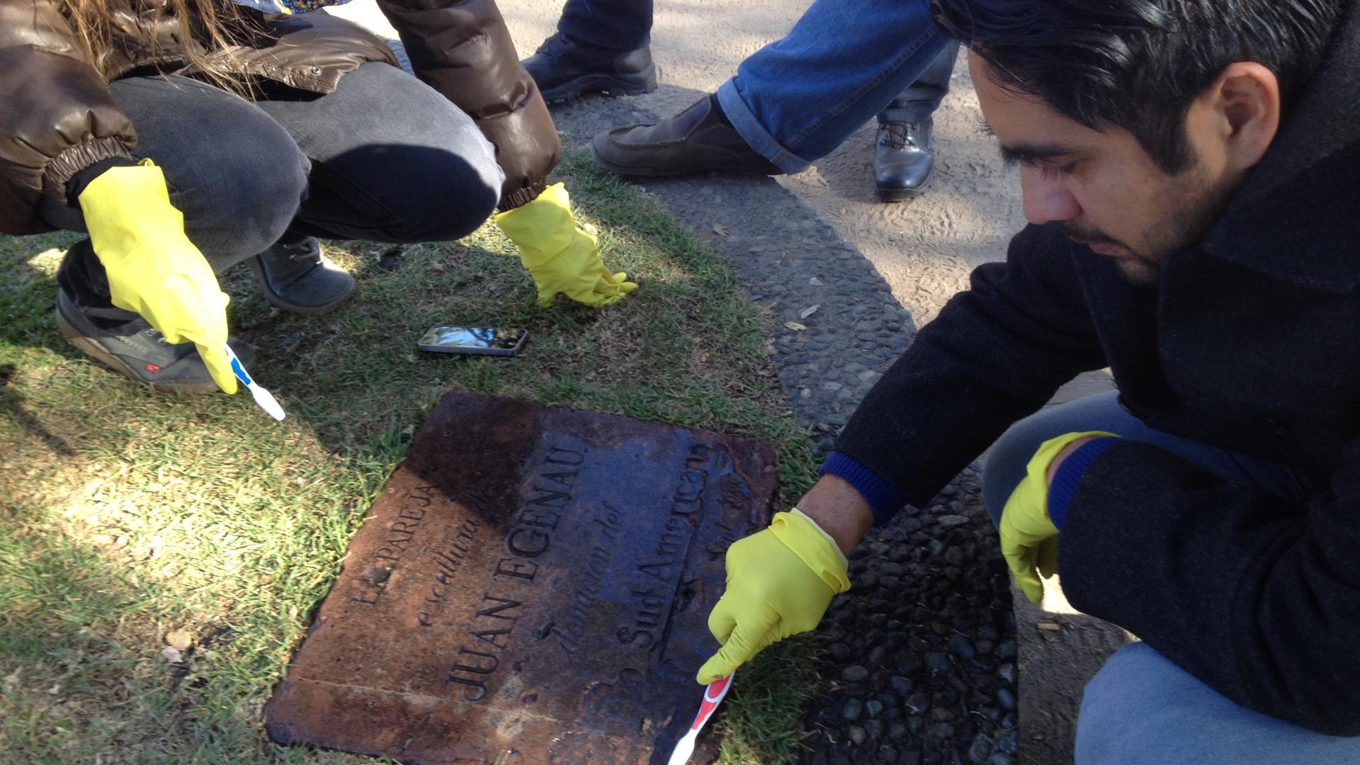 Proceso de limpieza de la placa de escultura "La Pareja" de Juan Egenau.