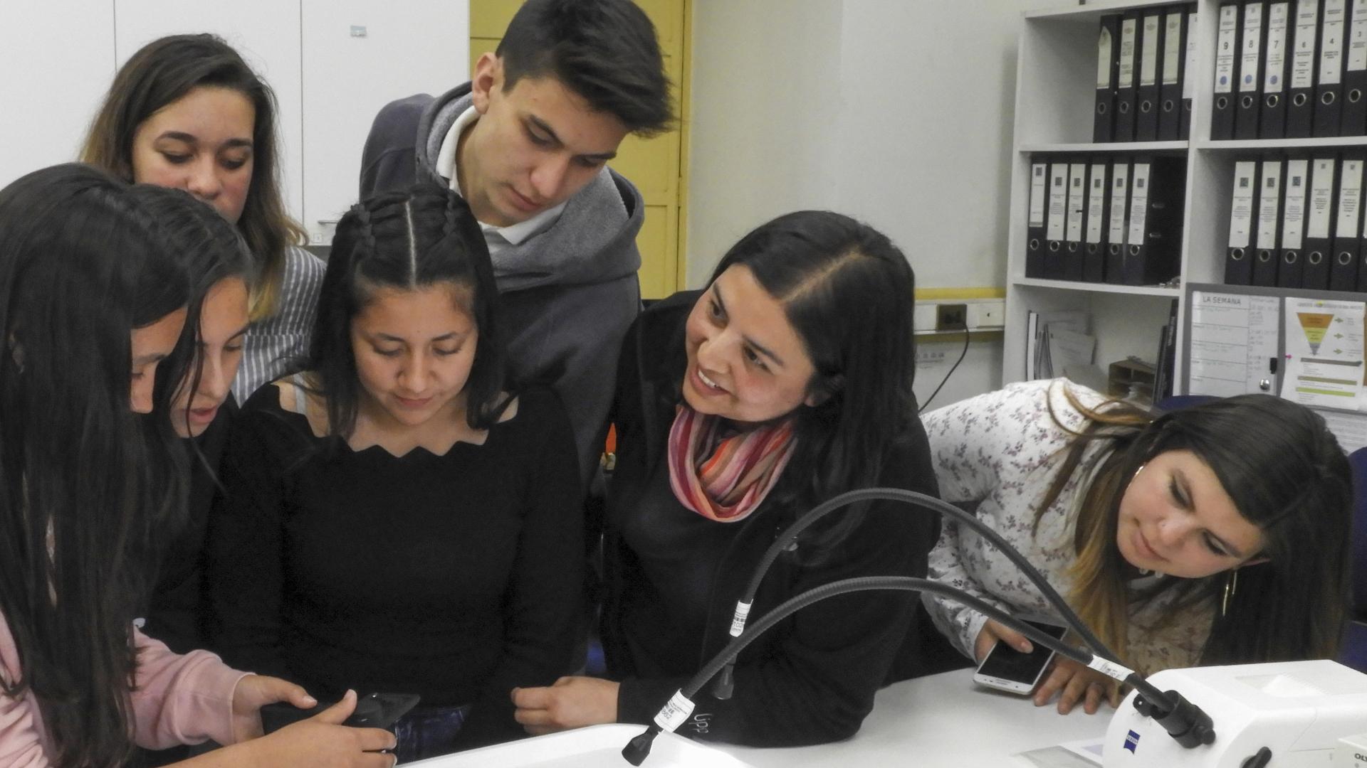 Estudiantes observando fibras textiles (prototipo) con microscopio portátil ( Archivo CNCR,  Dinator, M. 2018)