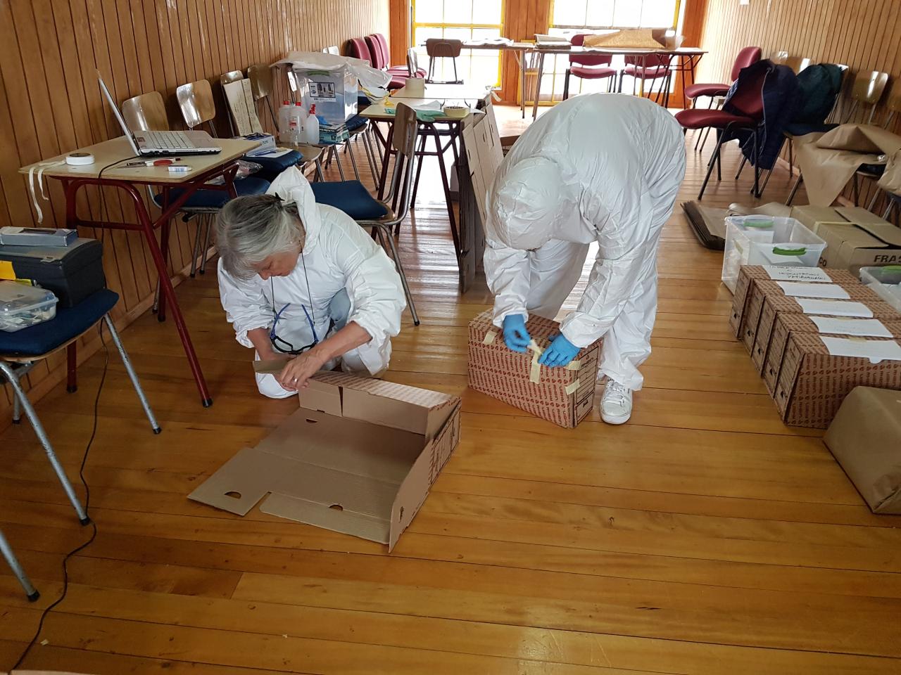 Sandra Santana y Cecilia Rodríguez, embalando los libros y documentos que ya pasaron por el proceso de limpieza y desinfección.