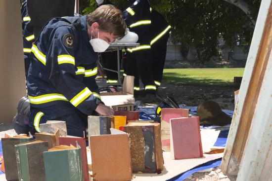 Ejercicio de rescate de bienes patrimoniales durante un incendio en depósito: rescate y secado de libros mojados.