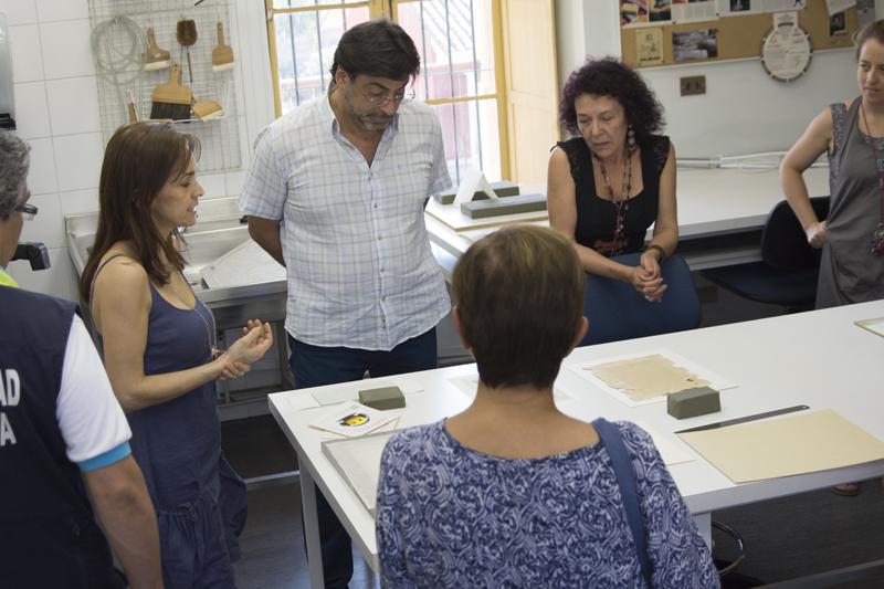 En el Laboratorio de Papel y Libros Soledad Correa muestra un documento histórico.