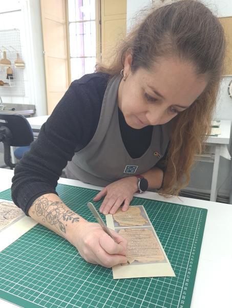 Desbastando con bisturí bordes del facsímil impreso en papel japonés