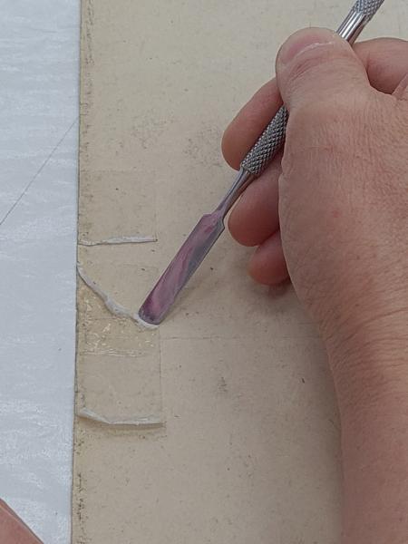 Figura 32. Claudia Pradenas durante el proceso de eliminación de cinta adhesiva de papel desde el reverso del sismograma núm.  28 del terremoto de 1960 (Fotografía: Hortuvia Atenas, V. 2021. 2021. Archivo CNCR. UPGD886.33). upgd886.33.jpg